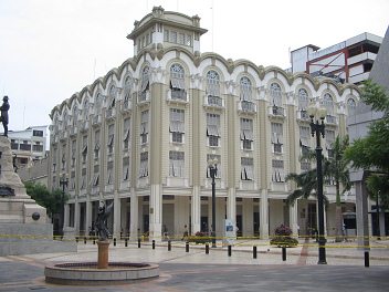 Centro de Guayaquil, un edificio de la
                          administracin municipal en blanco, un viejo
                          edificio bello, y antes hay una fuente de
                          ngel, a la izquierda el monumento Sucre