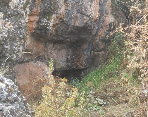 Cusco Sacsayhuamán, Zone X (Laq'o, Laco, Mondtempel), umgestürzter, schwarz-roter Felsen mit umgedrehtem Thron - Nahaufnahme