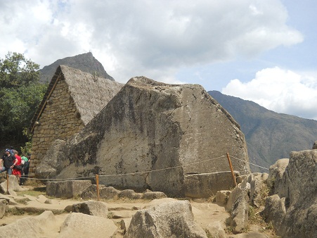 Machu Picchu, piedra sagrada, vista de atrs
                    con casita, son superficies gigantes cortadas