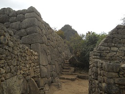 Entre la piedra sagrada y las casitas de obra:
                    muros con el mirador Huaynapicchu