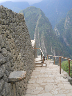 Ein Mauervorsprung an einer der Mauern von Machu Picchu mit dem Putucusi-Berg im Hintergrund
