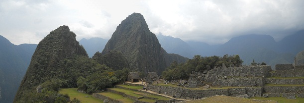 Machu Picchu: Sicht von der Sonnenpyramide auf
                    die beiden Hausberge Huchuypicchu und Huaynapicchu
                    mit der Silhouette eines Adlers, der die Flgel
                    anhebt - Panoramafoto 02