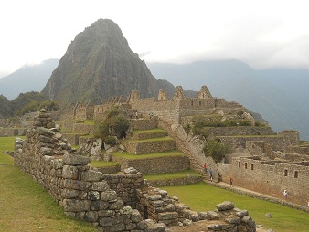 Machu Picchu, Sicht von der grossen Terrasse
                    neben dem Zentralplatz zum Hausberg Huaynapicchu,
                    Arbeitshuser, Spiegeltempel und die grosse Mauer