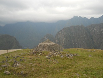 Machu Picchu, der Zeremonialstein auf einem
                    Feld, Sicht auf die Spitze 1
