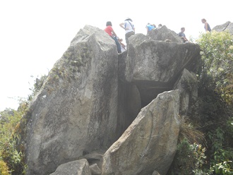Sicht auf den Gipfel von Huaynapicchu mit dem Steinbruch mit geschnittenen Gigasteinen, die einen zweiten Tunnel bilden 01