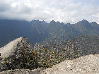 Der Berggipfel von Huaynapicchu, ein Steinbruch mit geschnittenen Gigasteinen auf dem Gipfel, Sicht auf die Berge 03