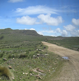 Der Feldweg mit Pftzenschlagloch und
                        Wolkenbild