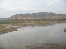 Panamericana in Nord-Peru zwischen Mancora
                        und Tumbes, Flussberquerung mit Wstenbergkette
                        im Hintergrund