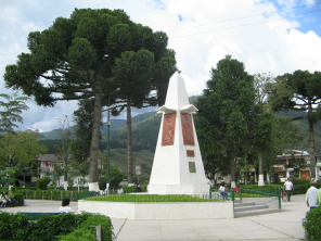 El monumento a la Plaza Central con figuras
                        de rboles, con placas de Yanesha / Amuesha
                        (izquierda) y con la "santa" Santa
                        Rosa (derecha)